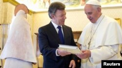 Durante el tradicional intercambio de regalos el presidente Juan Manuel Santos entrega al papa Francisco una edición especial de "Cien Años de Soledad" de Gabriel García Márquez.