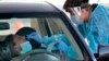 Petugas medis melakukan swab test "drive thru" terhadap seorang pengemudi di Phoenix, Arizona di tengah perebakan pandemi Covid-19. 
