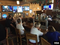 Para pengunjung restoran Harry Buffalo di luar arena debat, menyaksikan acara tersebut melalui televisi (6/8). (VOA/Kane Farabaugh)