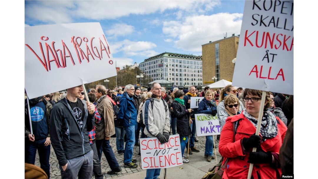 FILE - Demonstrators hold placards during the March for Science Stockholm manifestation at Medborgarplatsen square in Stockholm, Sweden, April 22, 2107.