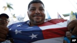 Un puertorriqueño partidario de la estatidad muestra su camiseta con la bandera de Estados Unidos.
