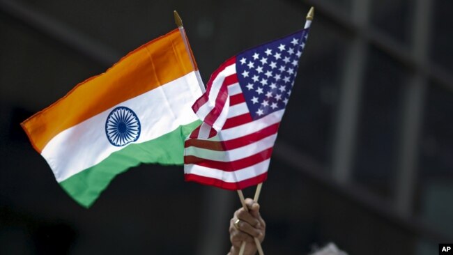 资料照片-在纽约市举行的印度日游行上，一名男子手持印度和美国国旗。(2015年8月16日)