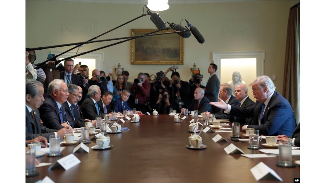 President Donald Trump, right, gestures while speaking during a meeting with Malaysian Prime Minister Najib Razak, second from left, in the Cabinet Room of the White House in Washington, Sept. 12, 2017.