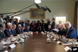 President Donald Trump, right, gestures while speaking during a meeting with Malaysian Prime Minister Najib Razak, second from left, in the Cabinet Room of the White House in Washington, Sept. 12, 2017.