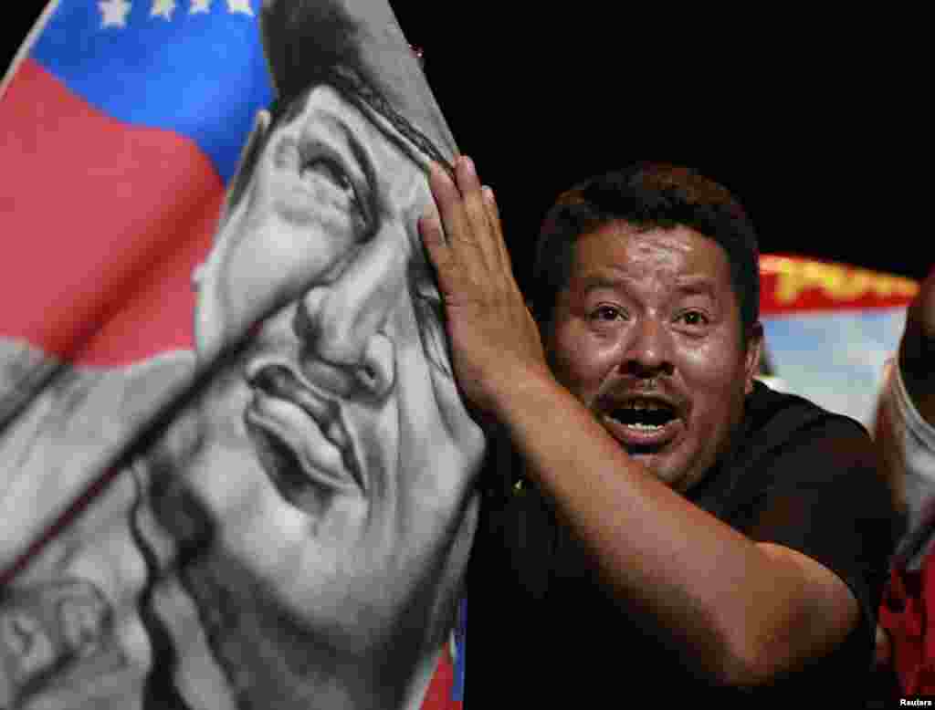 A supporter of Nicolas Maduro holds a banner with an image of late President Hugo Chavez as he celebrates after the official results gave Mr. Maduro a victory in the balloting, in San Salvador, April 14, 2013.