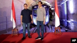 Indonesian President Joko “Jokowi” Widodo, right, stands on a stage with Jakarta Governor Anies Baswedan with the background of a Jakarta Mass Rapid Transit train during the inauguration ceremony of the subway line system in Jakarta, Indonesia, March 24, 2019.