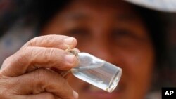 A local prospector displays flecks of gold found in the Klong Thong, or "Golden Canal" in Prachuap Khiri Khan province, southern Thailand, Jan. 19, 2017.