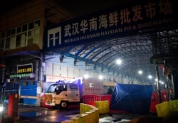 资料照片:中国湖北省武汉市卫生应急队的消毒车辆驶离已被关闭的武汉华南海鲜批发市场。（2020年1月11日）