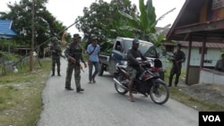 Pihak berwajib melakukan pemeriksaan terhadap kendaraan yang memasuki desa Pantangolemba, Poso Pesisir Selatan, Kabupaten Poso, Sulawesi Tengah (VOA/Yoanes).