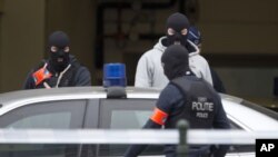 Un policier belge cagoulé devant un tribunal à Bruxelles, Belgique, 24 mars 2016.