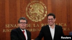 El senador mexicano Ricardo Moreal (izquierda) estrecha la mano de Juan Carlos Baker, subsecretario de Comercio Exterior de México el 30 de septiembre de 2018 tras el anuncio del acuerdo sobre comercio con EE.UU. y Canadá.
