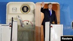 U.S. President Donald Trump waves upon his arrival at Paya Lebar Air Base in Singapore, before his summit with North Korean leader Kim Jong Un, June 10, 2018. 