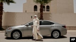 Ammal Farahat, who has signed up to be a driver for Careem, a regional ride-hailing service that is a competitor to Uber, poses for a photograph next to her car on a street in Riyadh, Saudi Arabia, June 24, 2018.