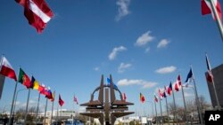 The NATO symbol and flags of the NATO nations outside NATO headquarters in Brussels on Sunday, March 2, 2014. 