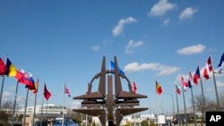 FILE - The NATO symbol and flags of the NATO nations outside NATO headquarters in Brussels, March 2, 2014. Officials from NATO and Russia are scheduled to hold their first formal meeting in almost two years, covering Ukraine, the security situation in Afghanistan, and military activities, the Western alliance said Tuesday.