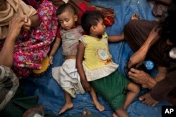 Two children sleep as Rohingya Muslims who have fled persecution in Myanmar wait along the border for permission to move further towards refugee camps near Palong Khali, Bangladesh, Nov. 2, 2017.