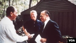 (1978年9月在美国马里兰州的戴维营，埃及总统萨达特(左)跟以色列总理贝京(右)握手，卡特站在旁边)