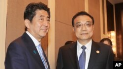2016年7月15日，日本首相安倍晋三与中国总理李克强在蒙古乌兰巴托举行的亚欧峰会期间举行双边会谈前握手。