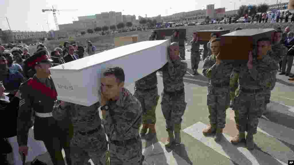 Des hommes portent des cercueils au cours des funérailles de quelques-uns des 900 migrants qui se noyés en tentant de rejoindre la côte sud de l&#39;Italie, à la périphérie de La Valette, à Malte, le 23 avril 2015.
