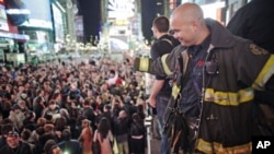 A firefighter waves to the crowd as people celebrate after Al Qaeda leader Osama bin Laden was killed in Pakistan, during a spontaneous celebration in New York's Times Square, May 2, 2011