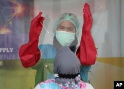 Seorang nakes bersiap melakukan tes usap Covid-19 di Laboratorium Genomik Solidaritas Indonesia di Jakarta, Senin, 14 Desember 2020.