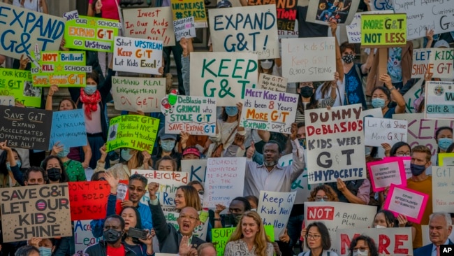 In this Thursday Oct. 14, 2021, file photo, protesters at City Hall condemn Mayor Bill de Blasio's plan to phase out the Gifted and Talented (G&T) public school program in New York. (AP Photo/John Minchillo, File)