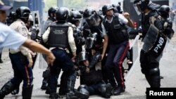 Police help an injured colleague during clashes with opposition supporters during protests against unpopular leftist President Nicolas Maduro in San Cristobal, Venezuela, April 19, 2017. 