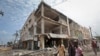 Men walk near destroyed buildings as thousands of Somalis gathered to pray at the site of the country's deadliest attack, Oct. 20, 2017. More than 300 people were killed and nearly 400 wounded in Saturday's truck bombing. 