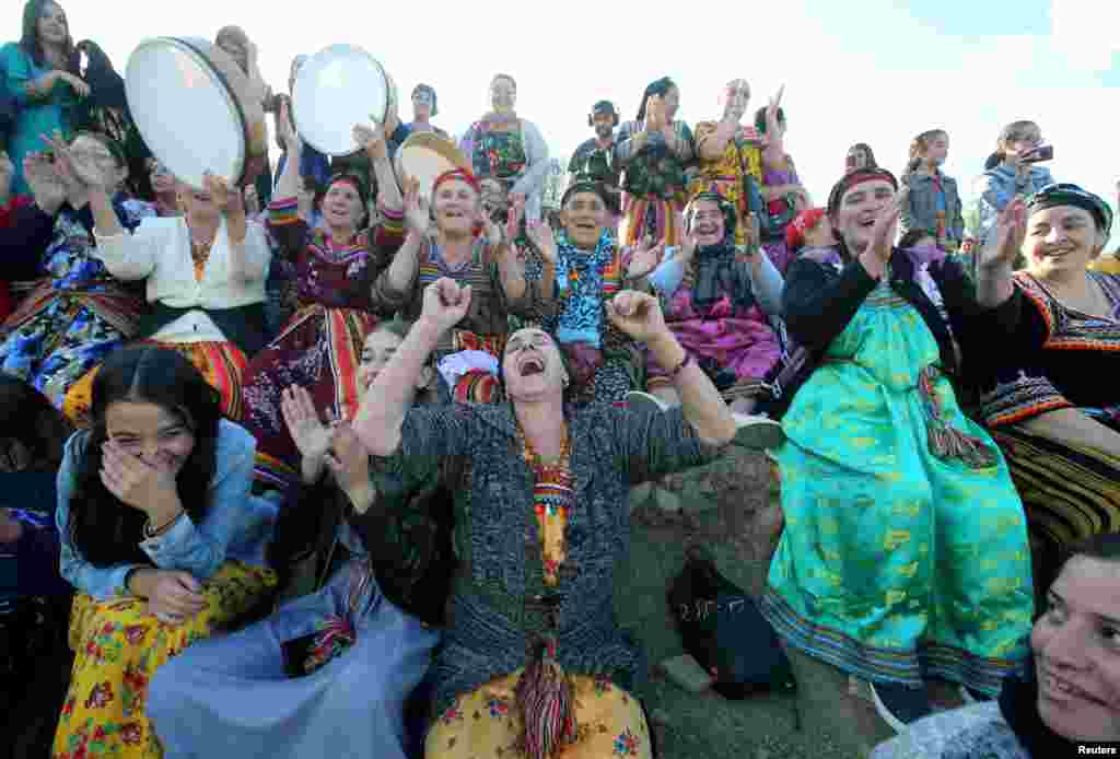 Women spectators cheer during a match in an annual local soccer tournament played by an all women teams, at the village of Sahel, in the mostly Berber Kabylie region in the mountains east of Algiers, Algeria.