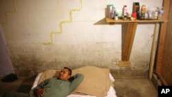 Toribio Jimenez lies on his bed in his basement bedroom of the home where he and 10 other people live in Nashville, Tenn, Sept. 3, 2009. Jimenez was given a job removing asbestos in the U.S. through the H2-B nonagricultural guest worker program. The job was not the job that was promised to him through the program, and after being fired, Jimenez said he now has no option but to work illegally so he can pay back the money he borrowed to make the trip to the U.S. 