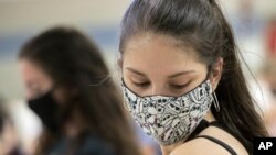 FILE - In this Thursday, April 8, 2021, file photo, Kent State University student Regan Raeth, of Hudson, Ohio, looks at her vaccination bandage as she waits for 15 minutes after her shot in Kent, Ohio. On Wednesday, May 12, 2021, Gov. Mike DeWine announc