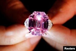 A Christie's staff holds a 18.96-carat Fancy Vivid Pink Diamond during a preview in Geneva, Nov. 8, 2018.