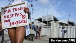 Une Ivoirienne tient une pancarte "Ma tenue n'est pas une invitation" lors d'une manifestation contre la chaîne de télévision Nouvelle Chaîne Ivoirienne (NCI) à la suite d'une émission choquante sur le viol, au siège du NCI à Abidjan le 1er septembre 2021