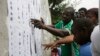 FILE - Nigerian people look for their names before they register to vote in Lagos, Nigeria, April 11, 2015. 