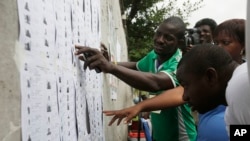 FILE - Nigerian people look for their names before registering to vote in Lagos, Nigeria, April 11, 2015. 