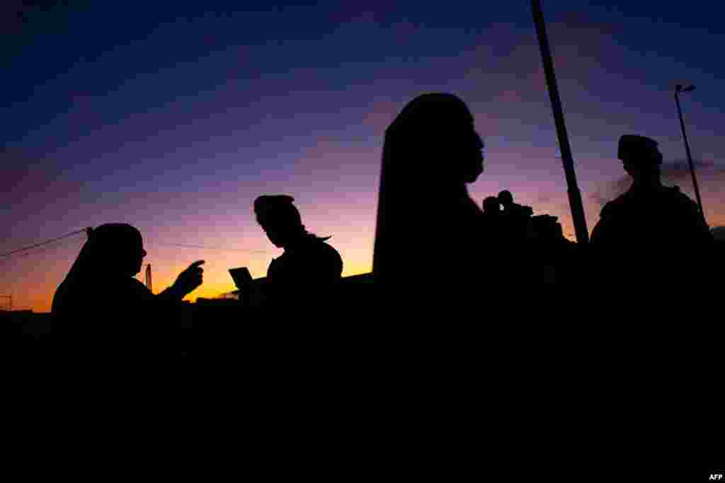 August 5: Palestinian women wait to cross the Qalandia checkpoint on their way to pray at the Al Aqsa Mosque on the first Friday of the Muslim holy month of Ramadan. (AP Photo/Bernat Armangue)