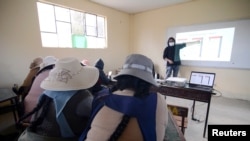 Parents attend a lesson on how to handle a smartphone for virtual home schooling for their children, during the coronavirus disease (COVID-19) outbreak, in El Alto, Bolivia July 12, 2021. Picture taken July 12, 2021. REUTERS/Claudia Morales