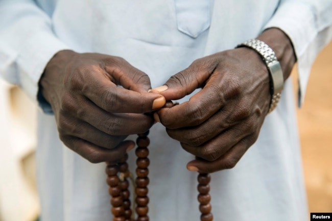 FILE - A Muslim holds Prayer beads outside a mosque in the town of Koui, Central African Republic, April 27, 2017.