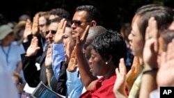 FILE - Candidates for naturalization take the Oath of Citizenship during a ceremony at George Washington's Mount Vernon estate, July 4, 2012, in Alexandria, Virginia.