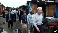 US Secretary of Health and Human Services Tom Price, right, walks May 18, 2017 through a densely-populated and heavily congested Monrovia, Liberia, slum community which was quarantined in 2014 when Ebola struck there killing dozens. 