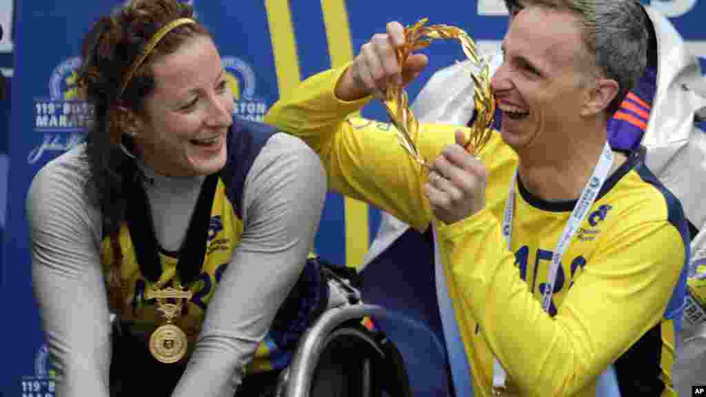 Bill Richard, right, father of 2013 Boston Marathon bombing victim Martin Richard, prepares to put the victor's wreath on women's wheelchair division winner Tatyana McFadden, of Russia, at the Boston Marathon, Monday, April 20, 2015 in Boston. (AP Photo/C