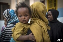 Sudanese refugees, who fled from the clashes between forces loyal to the internationally recognized Government of National Accord and forces loyal to strongman Khalifa Haftar, rest at a school in Libya's capital, Tripoli, on April 24, 2019.