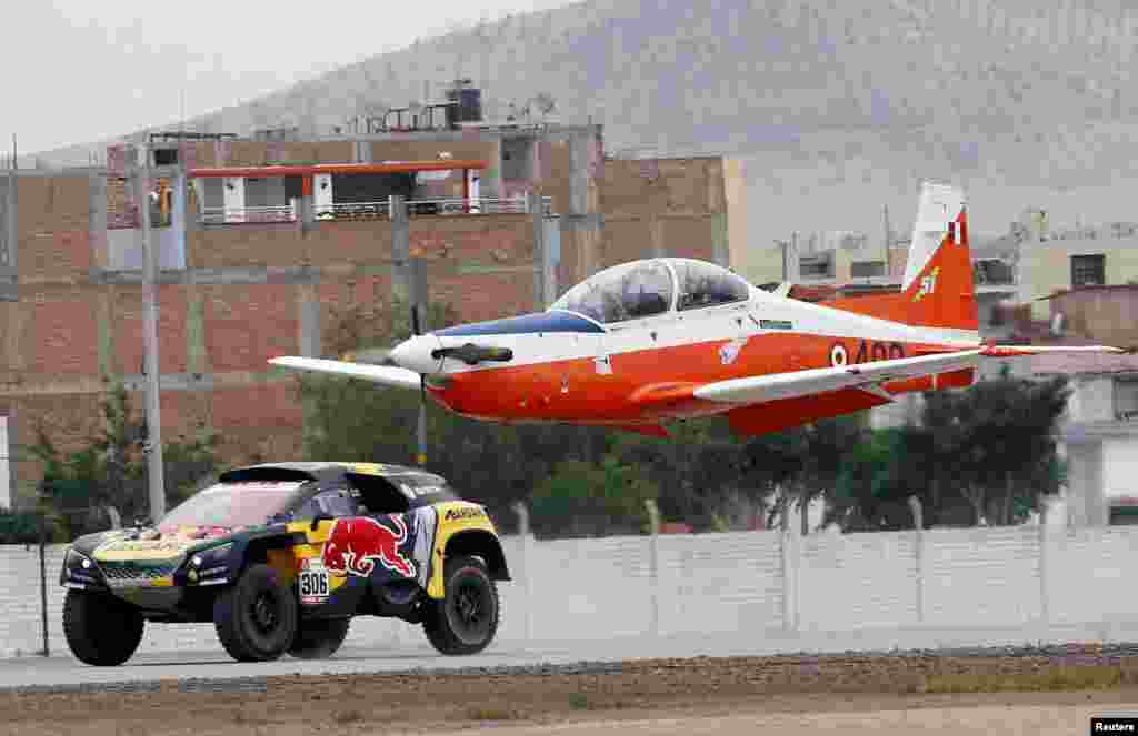 PH Sport&#39;s driver Sebastian Loeb of France and co-driver Daniel Elena of Monaco race their Peugeot against an airplane during a demonstration ride at the Las Palmas air base in Lima, Peru, Jan. 6, 2019.