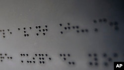 FILE - A text translated in Braille is displayed in an exhibition for blind and visually-impaired people at Louvre Museum in Paris.
