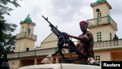 Soldiers from the Seleka rebel alliance stand guard as the Central African Republic's new President Michel Djotodia (not pictured) attends Friday prayers at the central mosque in Bangui, Mar. 29, 2013. 