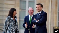 El presidente francés, Emmanuel Macron (derecha), la alcaldesa de París, Anne Hidalgo y el ex alcalde de Nueva York Michael Bloomberg durante una visita al Palacio del Eliseo en París, el 2 de junio, de 2017.