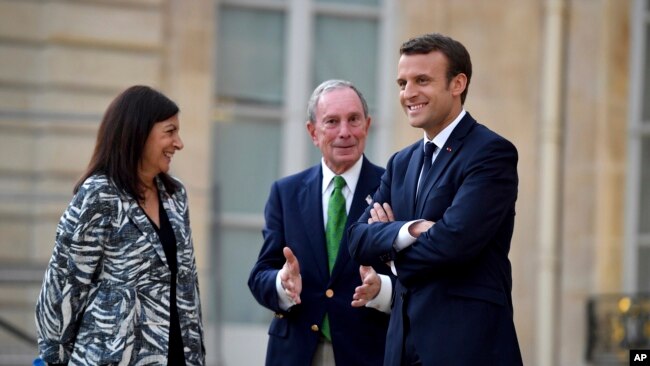 El presidente francés, Emmanuel Macron (derecha), la alcaldesa de París, Anne Hidalgo y el ex alcalde de Nueva York Michael Bloomberg durante una visita al Palacio del Eliseo en París, el 2 de junio, de 2017.