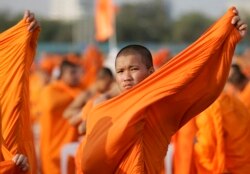 Seorang biksu Thailand membenahi jubahnya saat ia bergabung dengan sesama biksu dari seluruh Thailand untuk berdoa bagi perdamaian di Taman Sanam Luang, menghadap ke Royal Grand Palace, di Bangkok. (Foto: REUTERS/Adrees Latif)