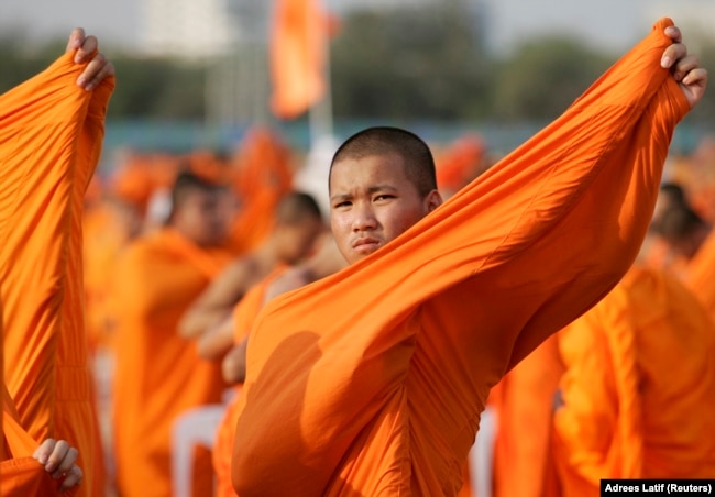 Seorang biksu Thailand membenahi jubahnya saat ia bergabung dengan sesama biksu dari seluruh Thailand untuk berdoa bagi perdamaian di Taman Sanam Luang, menghadap ke Royal Grand Palace, di Bangkok. (Foto: REUTERS/Adrees Latif)