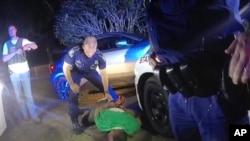 FILE — This image taken from video from Louisiana state trooper Lt. John Clary's body-worn camera shows trooper Kory York standing over Ronald Greene on his stomach on May 10, 2019, outside of Monroe, La.